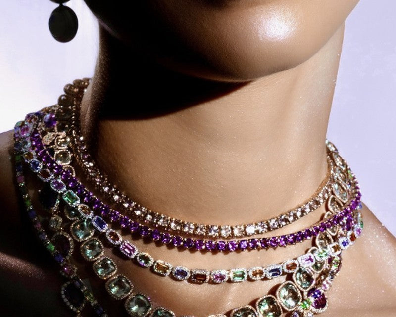 Layered gemstone and diamond necklaces worn together