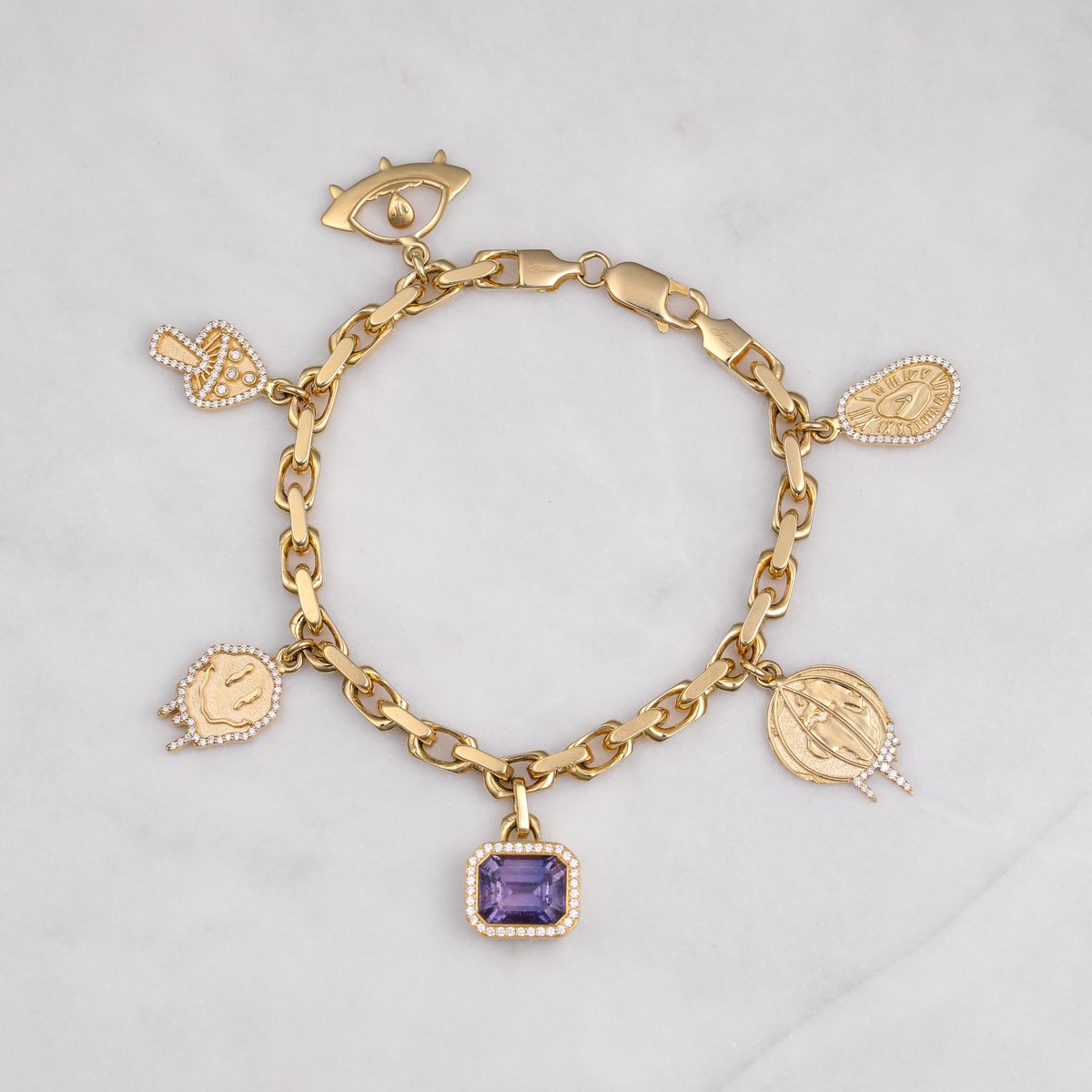Custom yellow gold charm bracelet with engraved medallions and an amethyst charm