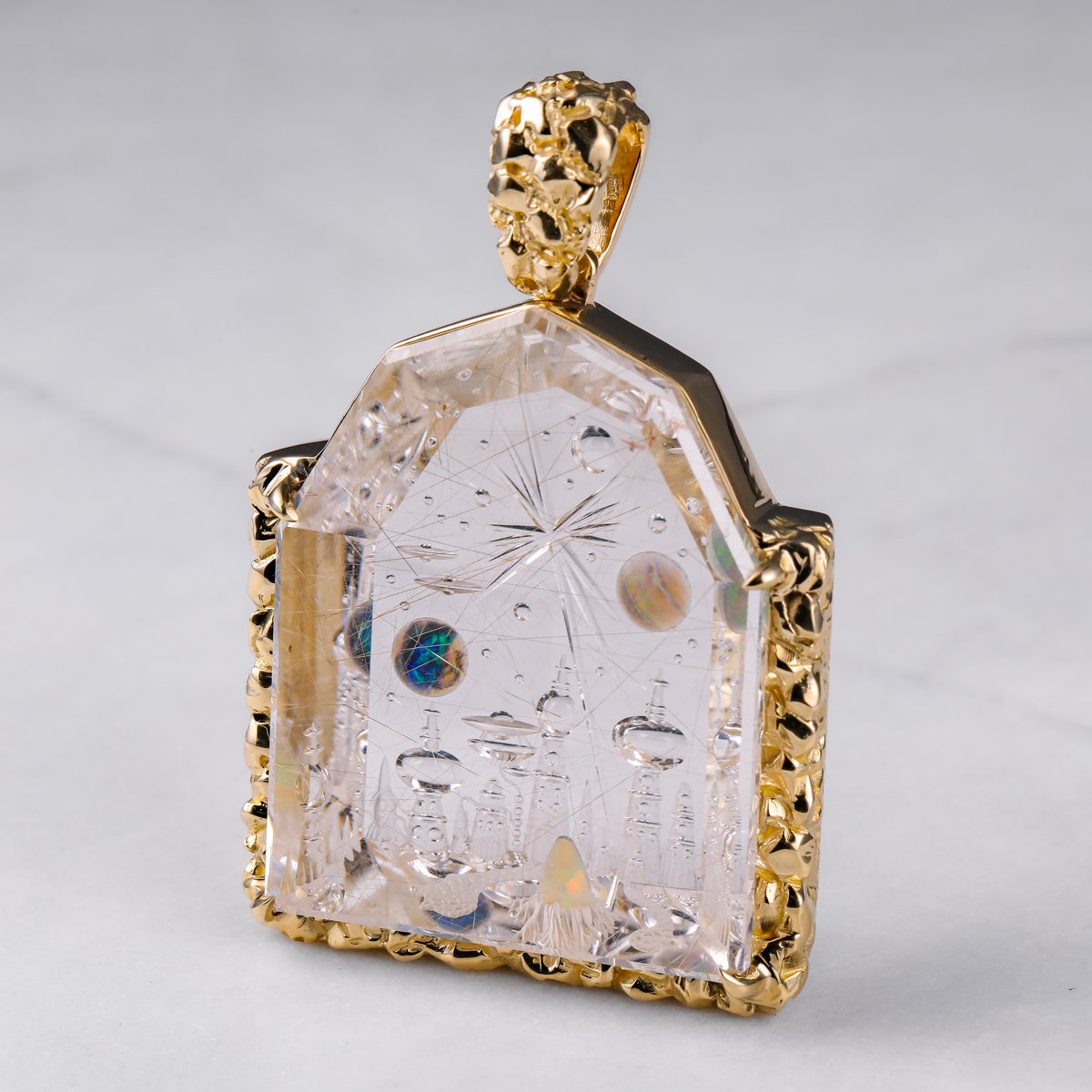 Custom carved crystal pendant with an opal-set cityscape in a nugget gold frame