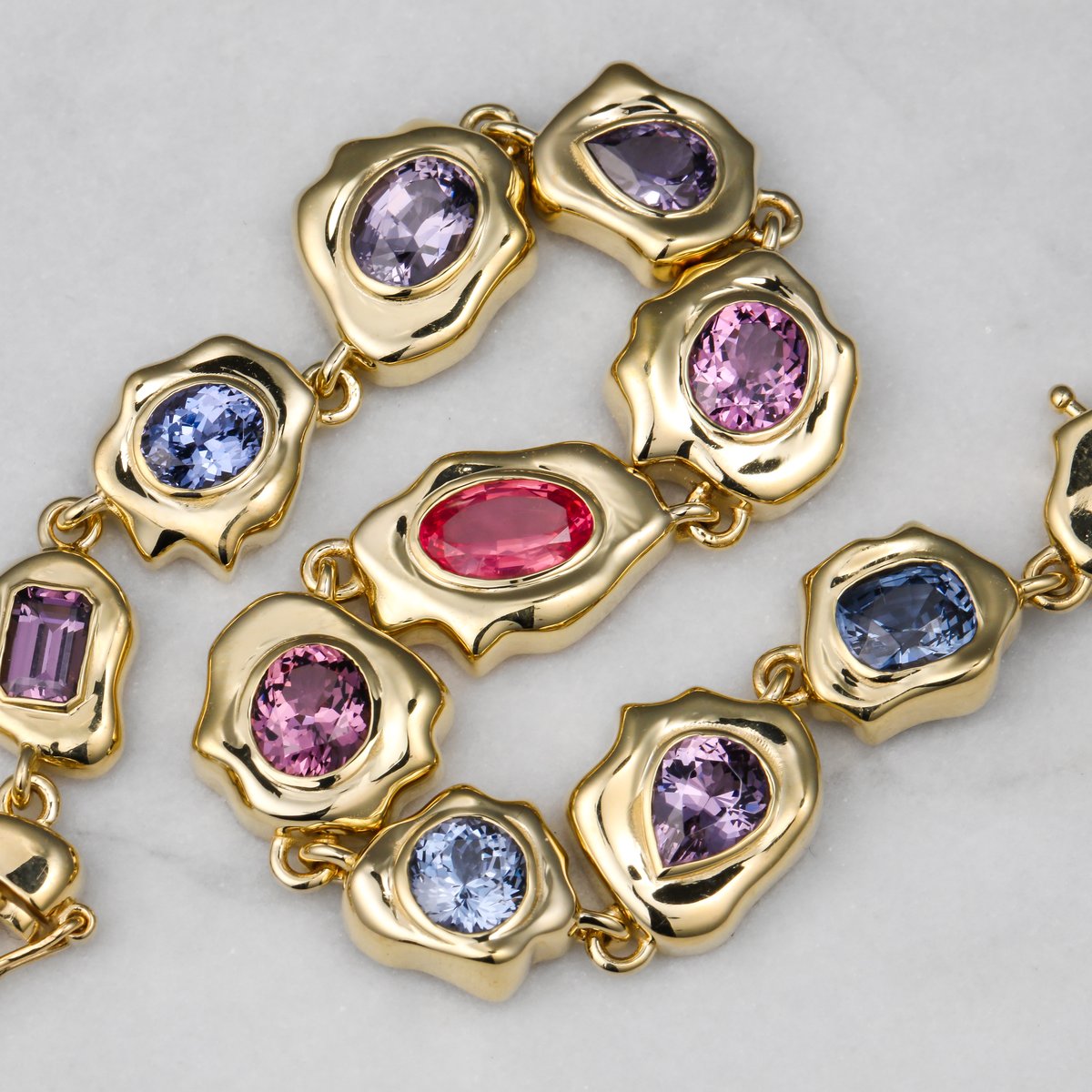 Custom bracelet of organic gold links set with multicolor gemstones